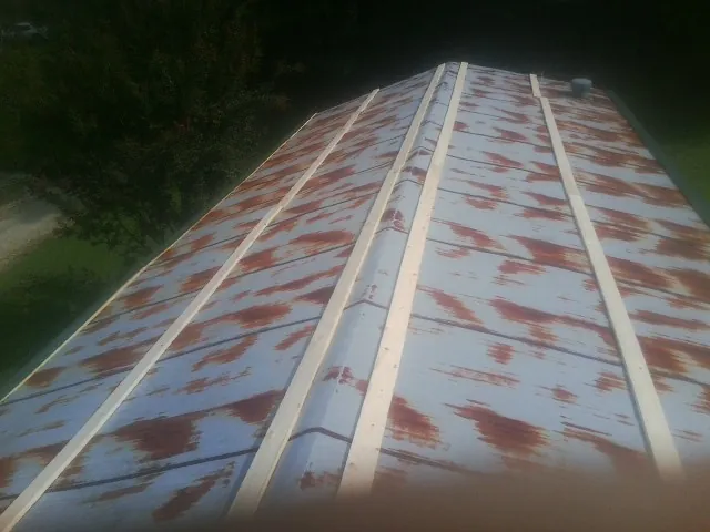 Rusted metal roof panels with new wood purlins before replacement — Storm Damage Roof Repair in Lemon Springs by Roofing Brothers
