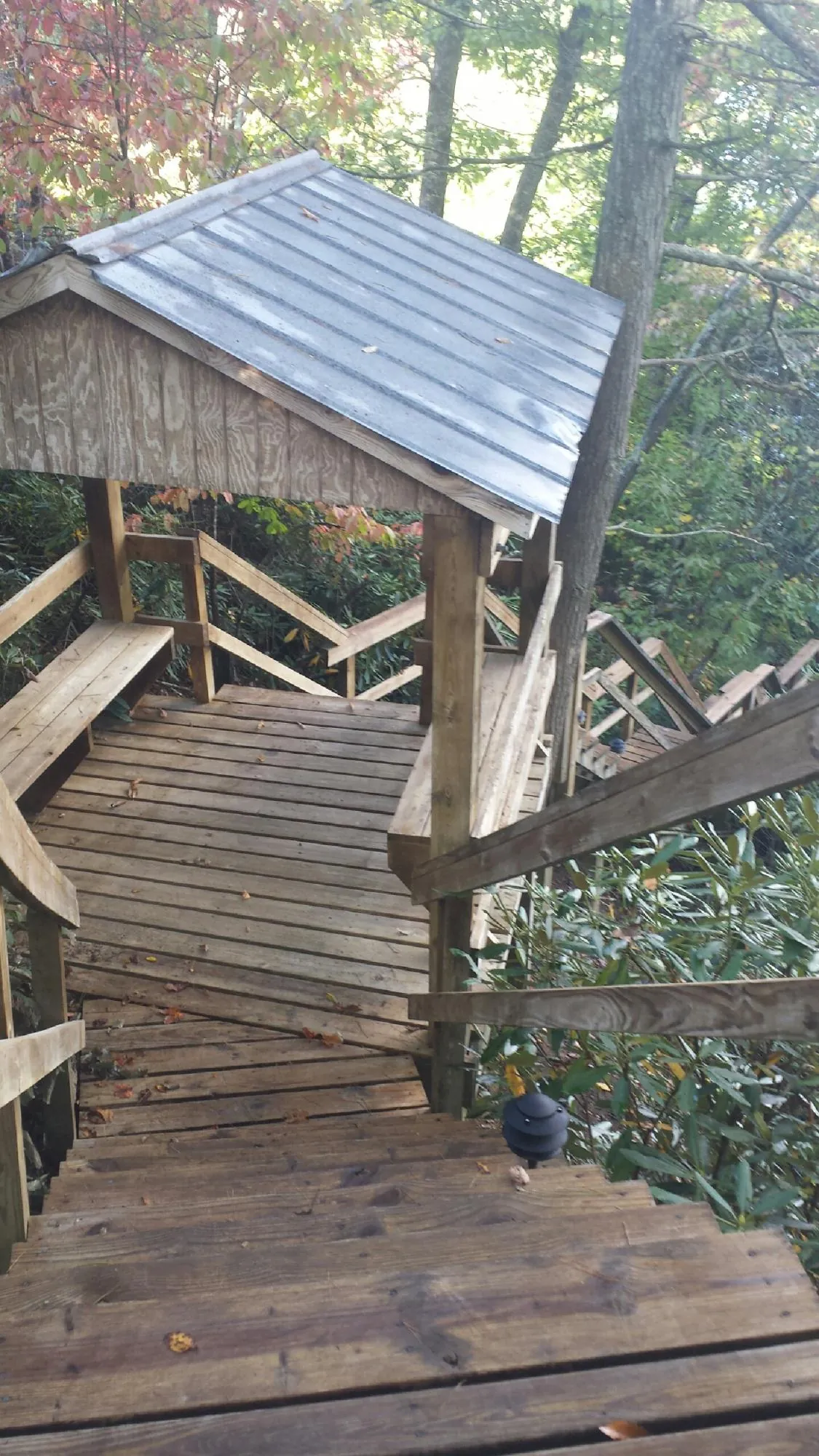 Metal roofed shelter over wooden steps on a wooded walkway — Skylight Repair & Installation work by our crew in Lemon Springs