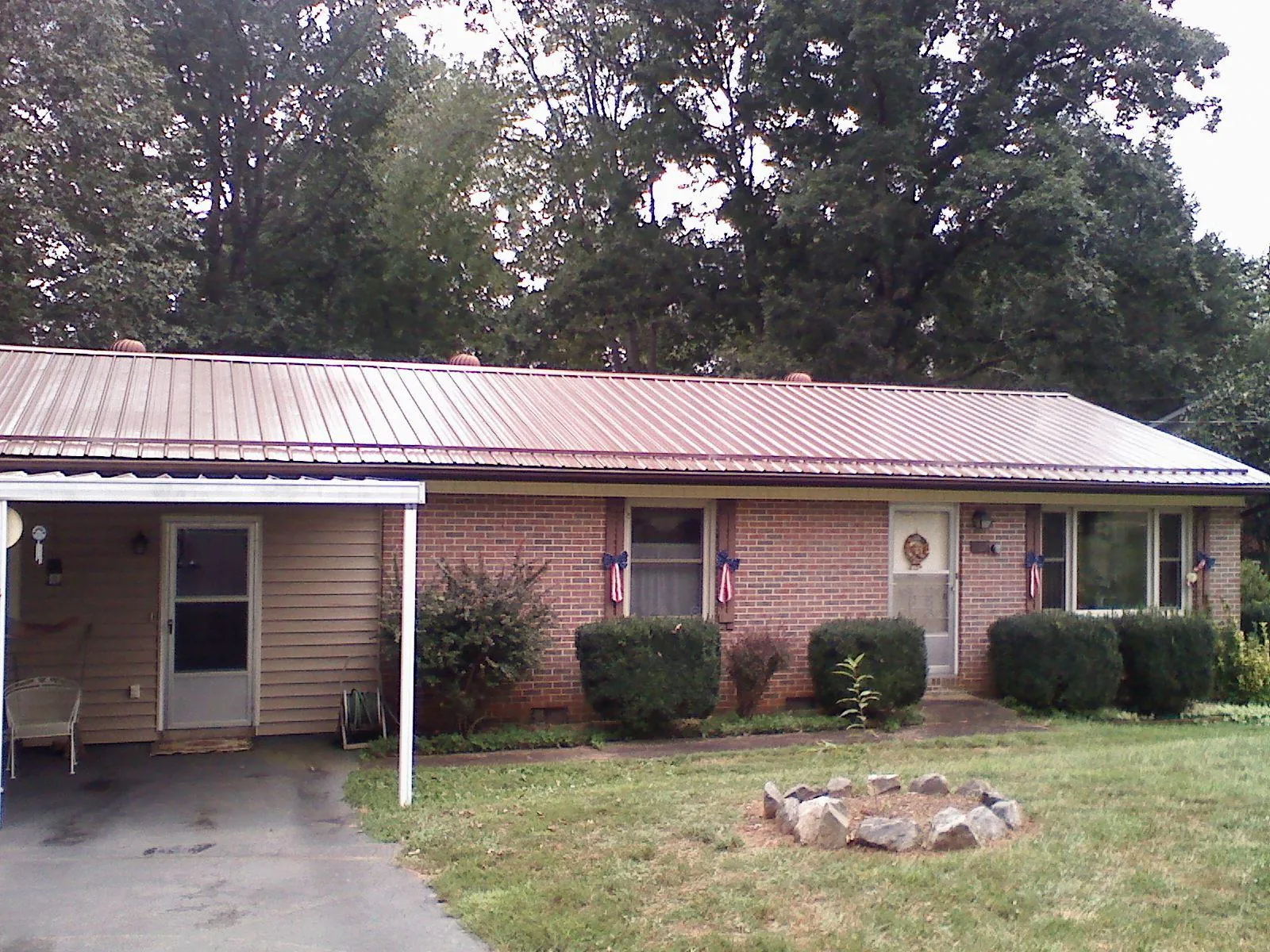 Bronze metal roof and carport on a brick ranch home — Roof Repair work by our crew in Lemon Springs
