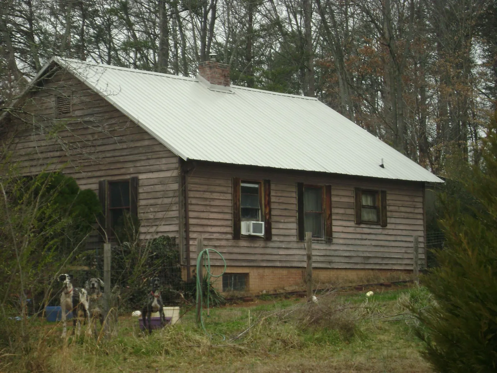 White metal roof on an old wood sided farmhouse, from a Metal Roof Installation job in Lemon Springs